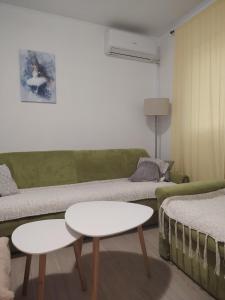 a living room with a green couch and a table at Apartman Vera in Bileća