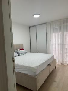 a bedroom with a large bed with white sheets at The Urban Oasis in Bar