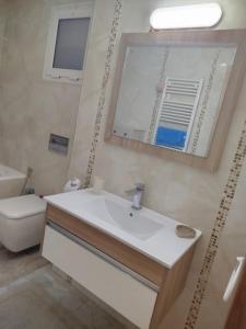 a bathroom with a sink and a mirror and a toilet at hedia a monastir in Monastir +13 photos