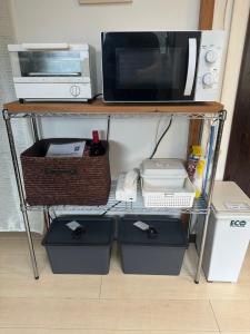 a shelf with a microwave and other appliances on it at Cottage Kirihata in Tanabe +19 photos