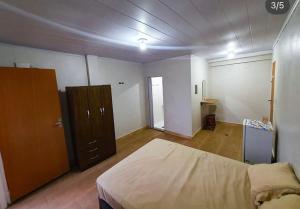 a bedroom with a large bed and a wooden cabinet at Recanto Remanso in Queimados