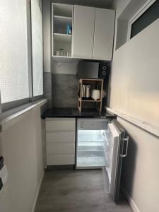 an empty kitchen with white cabinets and an open refrigerator at TAJ house center altea #A in Altea