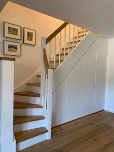 a staircase in a house with white walls and wooden floors at Maisonette Wohnung am Tegernsee in Bad Wiessee