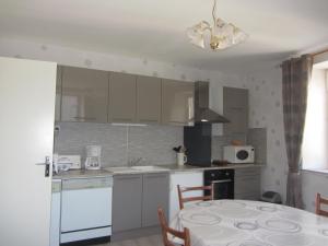 a kitchen with white cabinets and a table with a dining room at Gites familiaux à Lajoux à 1180m d'altitude in Lajoux