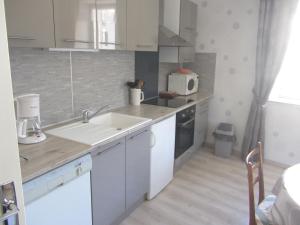 a white kitchen with a sink and a microwave at Gites familiaux à Lajoux à 1180m d'altitude in Lajoux