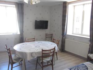 a dining room with a table with chairs and a tv at Gites familiaux à Lajoux à 1180m d'altitude in Lajoux