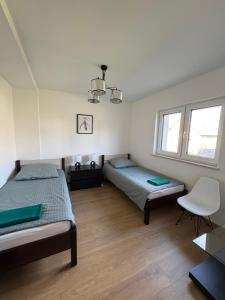 a bedroom with two beds and a chair in it at Biebrzańska Dolina 2 in Goniadz