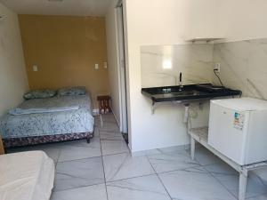 a small room with a bed and a sink at Kitnet Terreo Privada 1 in Conde