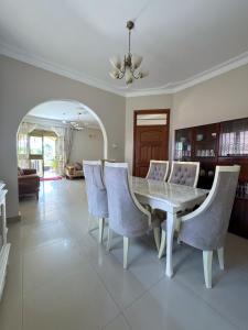 a dining room with a white table and chairs at The Terrace Villa in Kampala