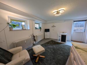 a living room with a couch and a chair at Gästezimmer am Deister in Barsinghausen