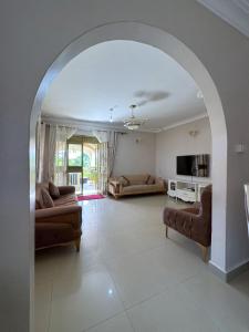 an archway in a living room with couches and a tv at The Terrace Villa in Kampala