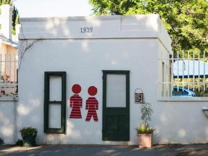 a white building with two people painted on it at Oude Pastorie in Cradock