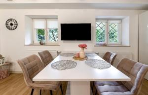 a dining room with a white table and chairs at Green House in Neunkirchen