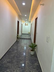 an empty hallway with a plant in a building at Hotel Elite in Palwal