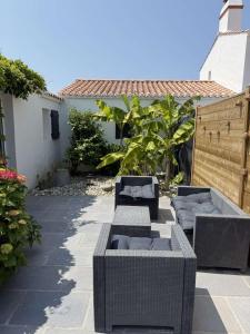 three wicker couches and chairs on a patio at Lanceanti in LʼÉpine