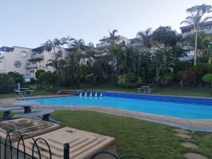 a swimming pool with a picnic table and some buildings at Aloe Shore- Whale Watch from Balcony- Stunning in Umdloti