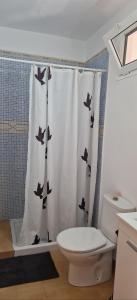 a bathroom with a shower curtain with birds on it at Casita Blum in La Asomada +16 photos