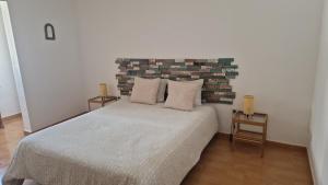 a bedroom with a large bed and a brick wall at Casita Blum in La Asomada