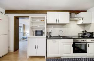 a kitchen with white cabinets and a sink and a microwave at Green House in Neunkirchen