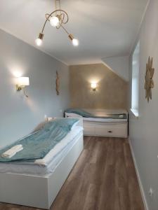 a bedroom with two beds and a ceiling at Domki Alpati in Jastrzębia Góra