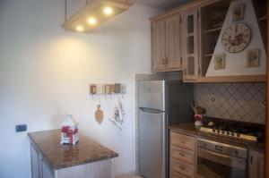 a kitchen with wooden cabinets and a white refrigerator at Three Tails House in Capezzano Pianore,