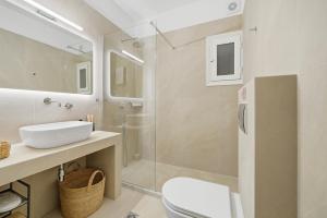 a bathroom with a sink and a toilet and a mirror at Calma Ioannina Apartment in Ioannina +18 photos