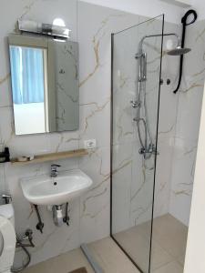 a bathroom with a sink and a glass shower at ChristAlex Guesthouse in Himare +51 photos