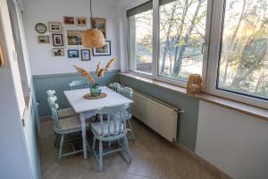a dining room with a table and chairs and windows at Dunai Menedék in Ráckeve +31 photos