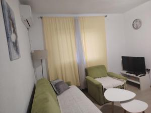 a small living room with a couch and a chair at Apartman Vera in Bileća