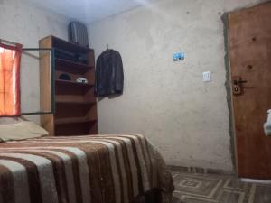 a bedroom with a bed with a blanket on it at El PRADO in Alta Gracia