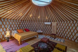 a bedroom in a yurt with a bed and a window at Amapolas agri glamping in Camerano