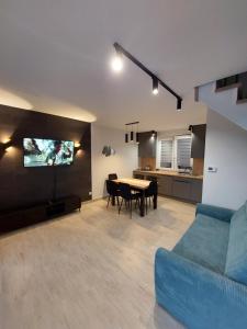a living room with a blue couch and a table at Domki Alpati in Jastrzębia Góra