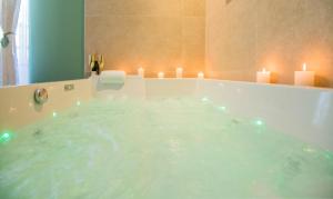 a bathroom with a tub with candles in it at Ecrin de bulles - Jacuzzi & clim in Les Cabannes