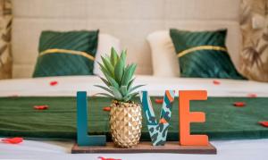 a table topped with a pineapple and the word love at Ecrin de bulles - Jacuzzi & clim in Les Cabannes
