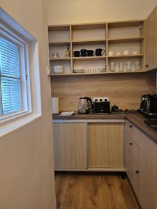a kitchen with wooden cabinets and a counter top at CsakMiKisház in Harkány