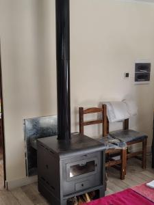 a stove in a living room with a chair and a table at El último Cartucho in Tandil