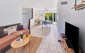 a living room with a couch and a tv at Villa La Dorada, Normandy in Ver-sur-Mer