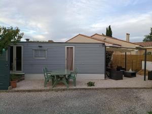 a picnic table in front of a tiny house at mobilhome Catalan in Néfiach +2 photos