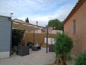 a backyard with a pergola and a building at mobilhome Catalan in Néfiach