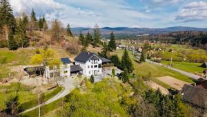 an aerial view of a white house on a hill at Cabana Transylwonder in Sicasău