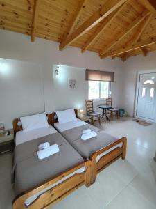 a bedroom with two beds and a table and chairs at ChristAlex Guesthouse in Himare