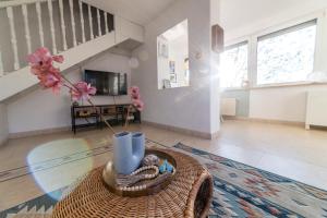a living room with a table with a vase at Dunai Menedék in Ráckeve