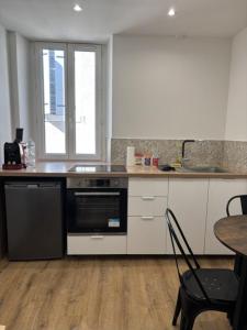 a kitchen with a black and white stove top oven at Cornas in Tournon-sur-Rhône