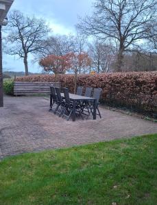 a picnic table and chairs on a brick patio at Wedderhoeske in Wedde