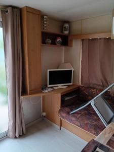 a small room with a desk with a computer on it at mobilhome Catalan in Néfiach