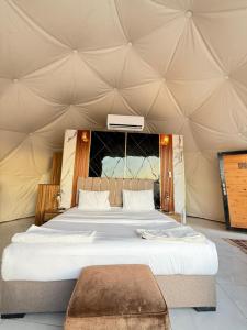 a bedroom with a large bed in a tent at Wadi Rum Nader Luxury Camp in Wadi Rum