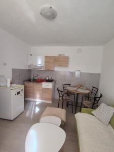 a living room with a table and a kitchen at Apartman Vera in Bileća +11 photos