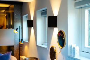 a room with a mirror and lights on the wall at La petite chambre in Bennekom
