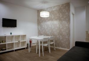 a living room with a white table and a tv at dellarocca4 in Cefalù