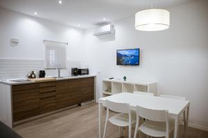 a kitchen with a white table and white chairs at dellarocca4 in Cefalù